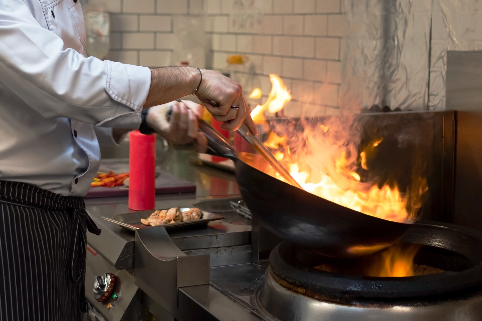 A man cooks cooking deep fryers in a kitchen fire.